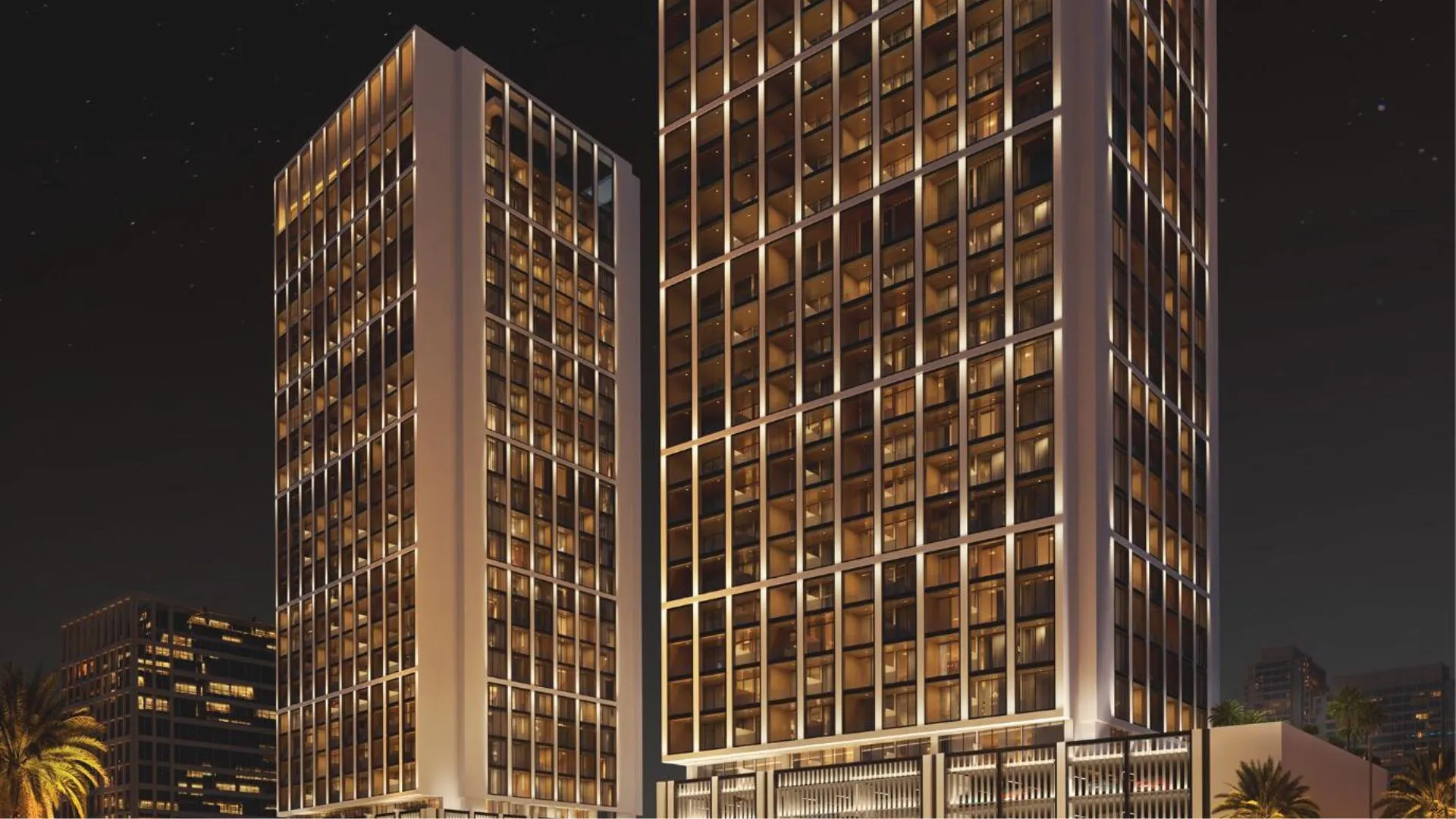 Tall, modern Binghatti Moonlight residential towers illuminate the night sky, showcasing many windows.