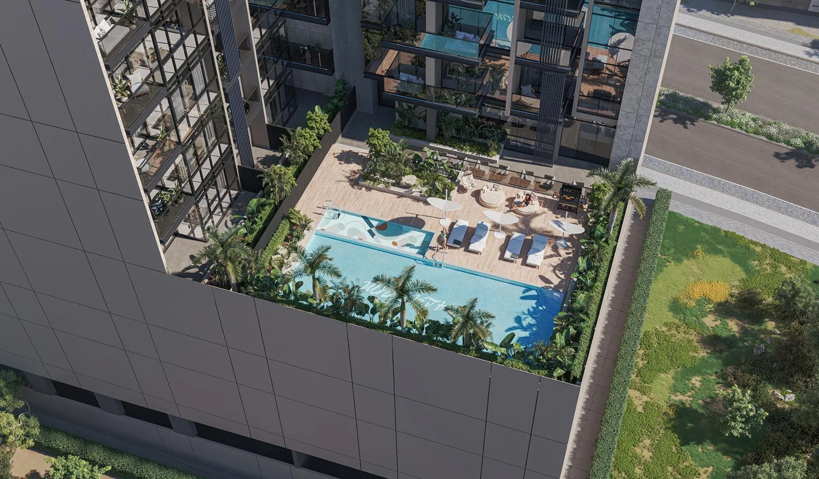 Aerial view of Palatium Residences pool deck with sun loungers, umbrellas, and lush greenery.