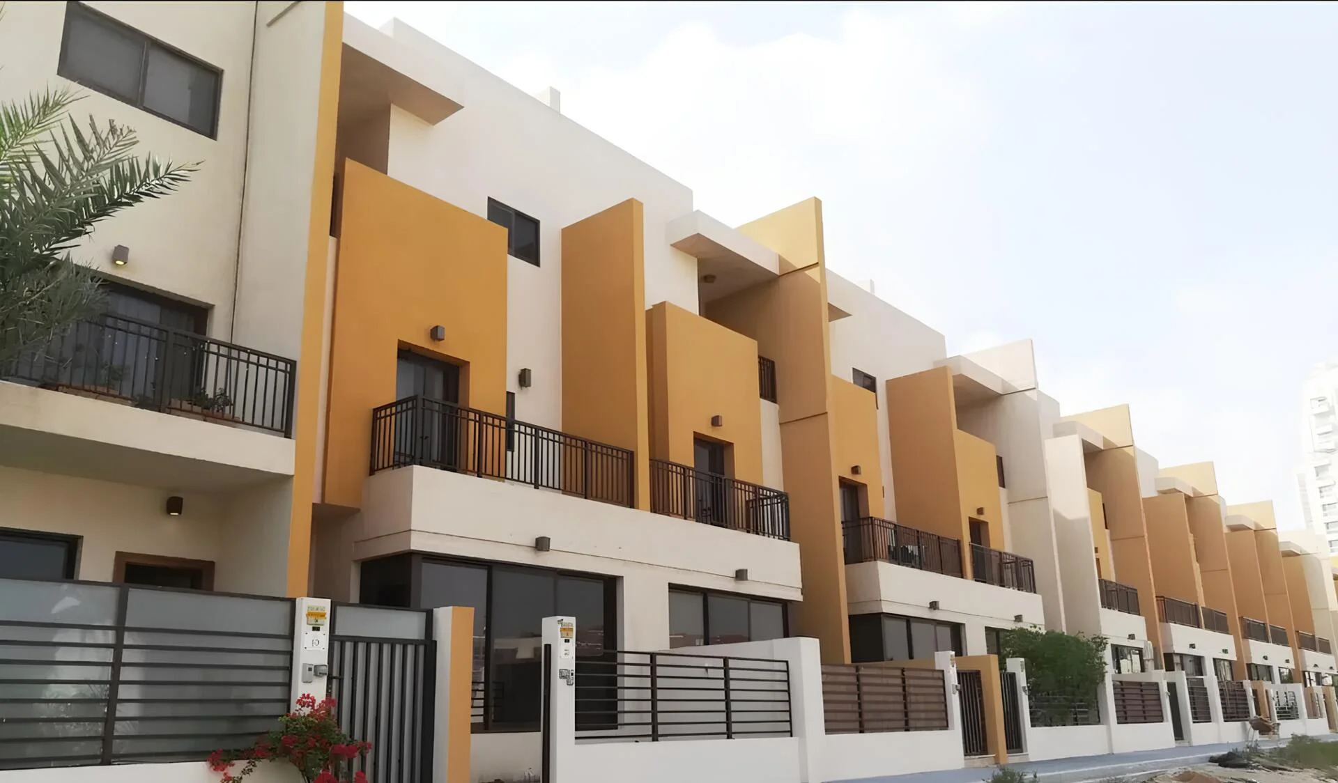 Modern three-story townhouses at Lilac Park with bold yellow accents and private balconies.